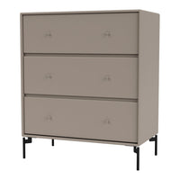 Beige three-drawer dresser with matte finish and black metal legs, featuring simple knob handles. Modern and minimalist design.