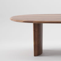 Walnut wood round table with a smooth, natural finish and rich, warm tones. Elegant, minimalistic design.
