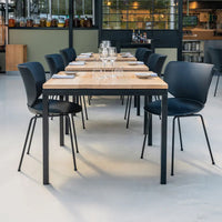 Modern wooden table with a natural finish, paired with sleek black chairs, creating a stylish, minimalist dining setup.