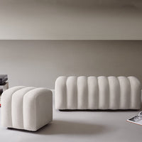 Cream ribbed ottomans with curved silhouettes, adding softness and modern elegance to any interior design.