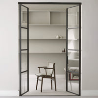 Black metal frame door with glass panels, showcasing a minimalist interior in soft neutral tones.