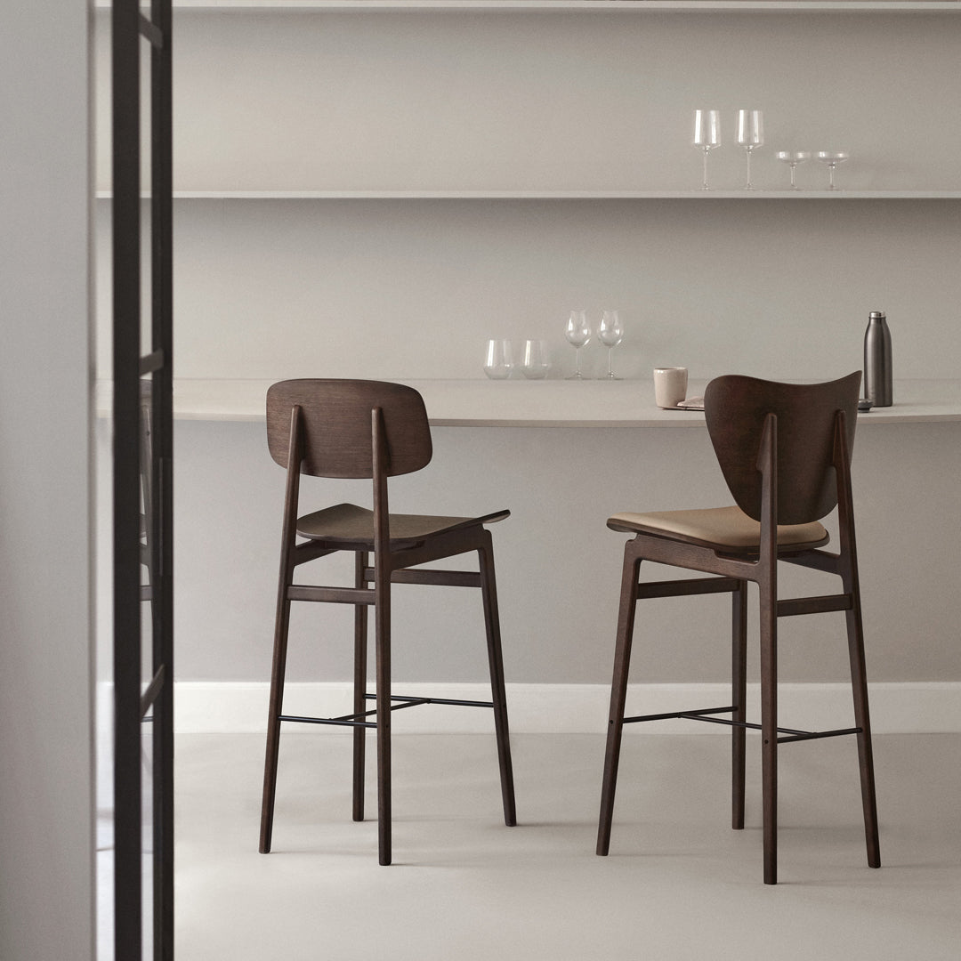 Two elegant wooden barstools in rich brown, featuring a smooth finish and simple, modern design against a neutral backdrop.