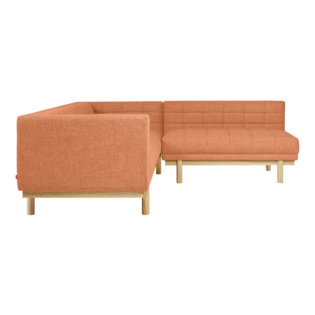Orange upholstered sectional sofa with a textured pattern and light wooden legs. Ideal for modern living spaces.