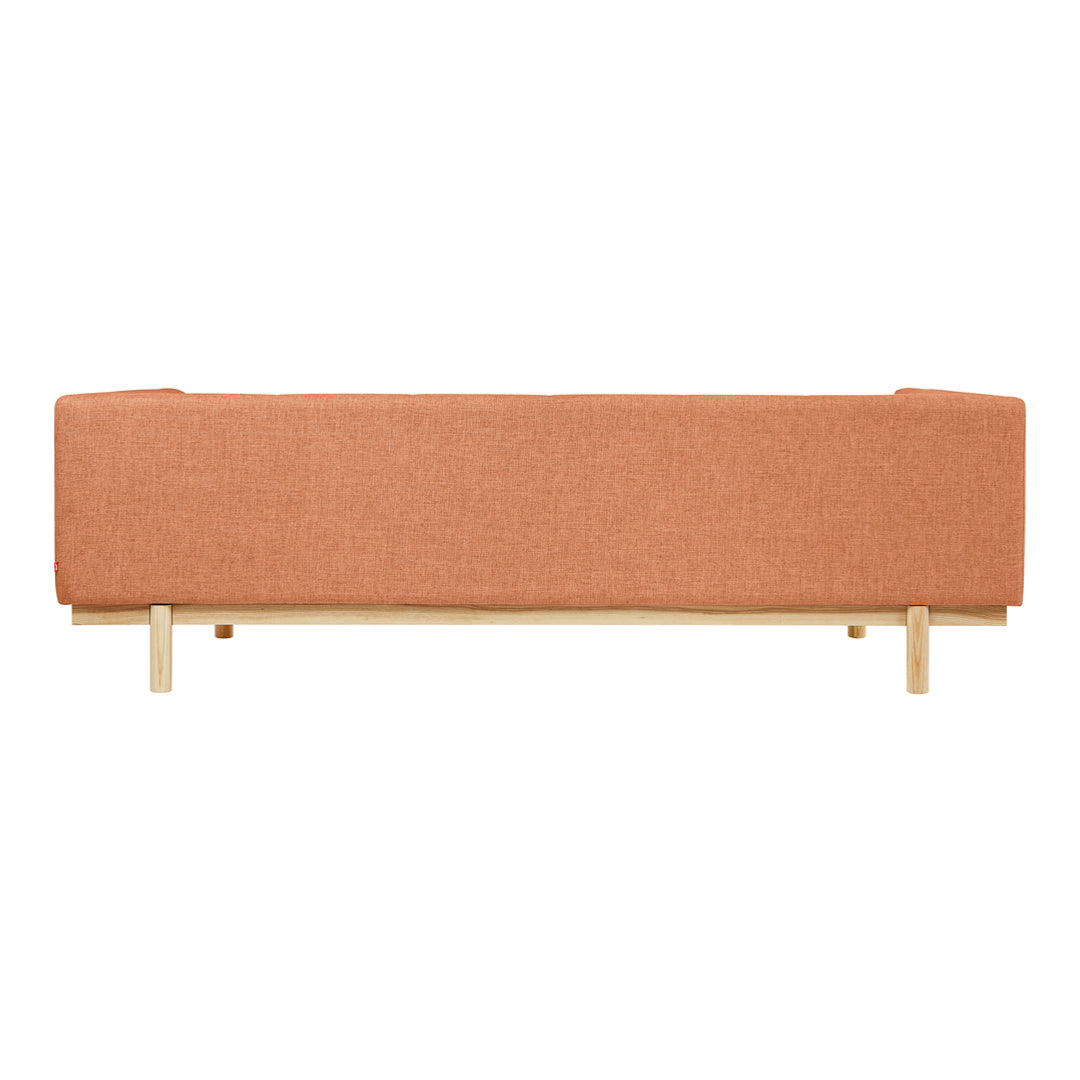 Rustic orange fabric sofa with clean lines and light wooden legs, perfect for modern living spaces.