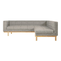 Gray upholstered sectional sofa with a quilted pattern and light wood legs, perfect for modern living spaces.