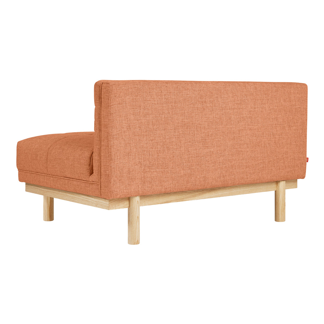Rust orange fabric sofa with a minimalist design and natural wood legs, featuring a subtle textured pattern.