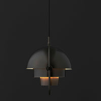 Modern black pendant lamp with layered dome design and warm accent lighting on a dark background.