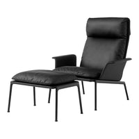 Black leather armchair with matching ottoman on a sleek metal frame, showcasing minimalist design and modern elegance.