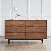 Wooden dresser featuring a rich walnut finish and smooth, minimalist lines against a neutral backdrop.