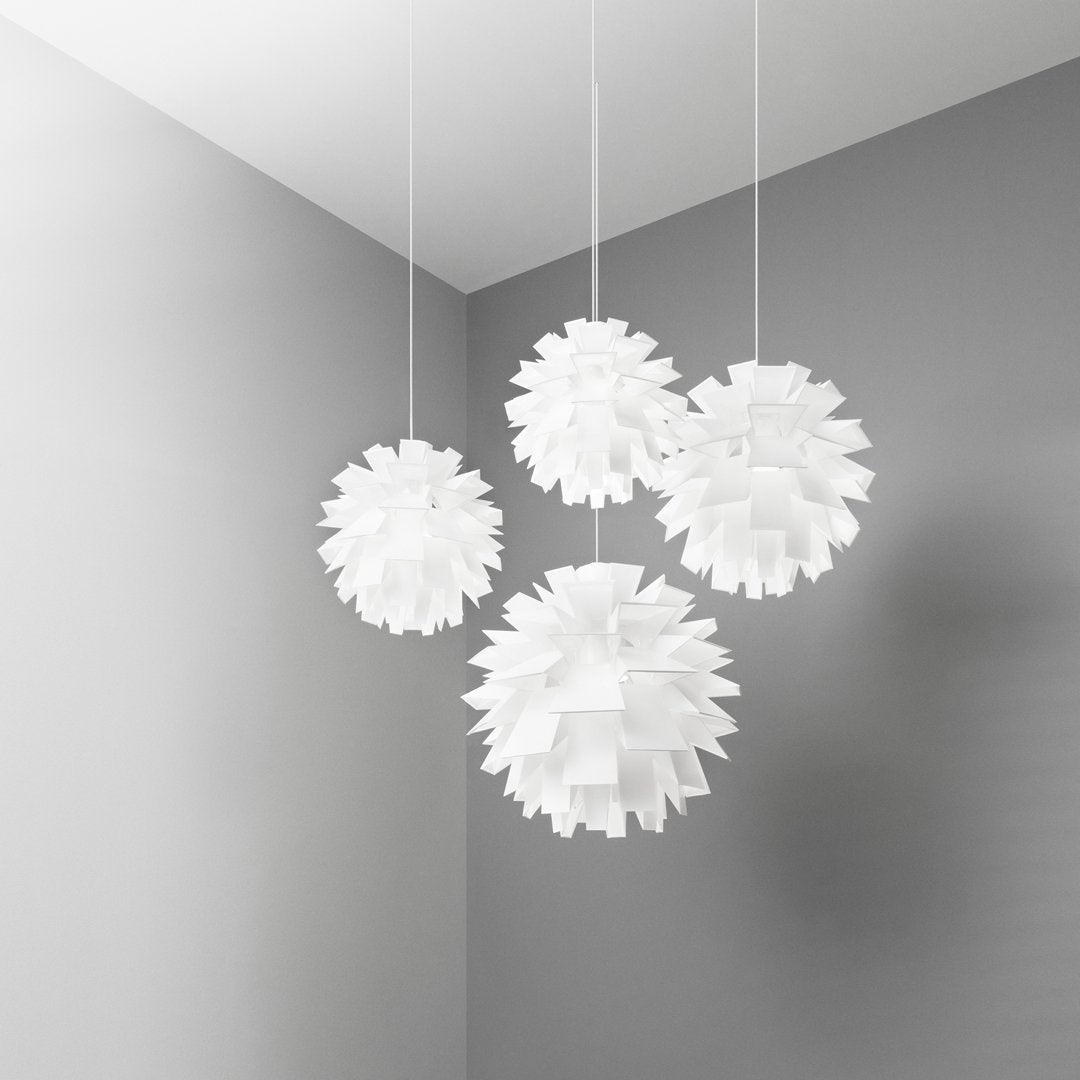 Modern white pendant light fixtures with textured, spherical designs, hanging against a soft gray wall.