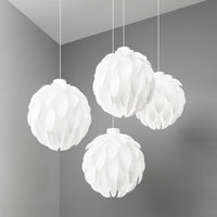 Four textured white pendant lamps with a leaf-like pattern, hanging against a soft gray wall.