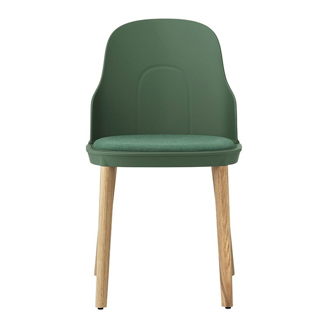 Green plastic chair with smooth surface and light wood legs, offering a modern and stylish design.