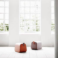 Two modern storage bags in soft pink and coral colors against a bright, sunlit window backdrop.