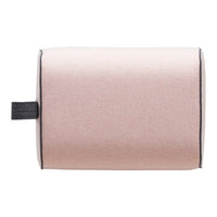 Soft pink cylindrical cushion with black piping and side handle, featuring a smooth, minimalist design.