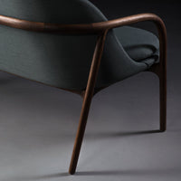 Gray upholstery with subtle texture, complemented by a sleek, dark wood frame and minimalist design.