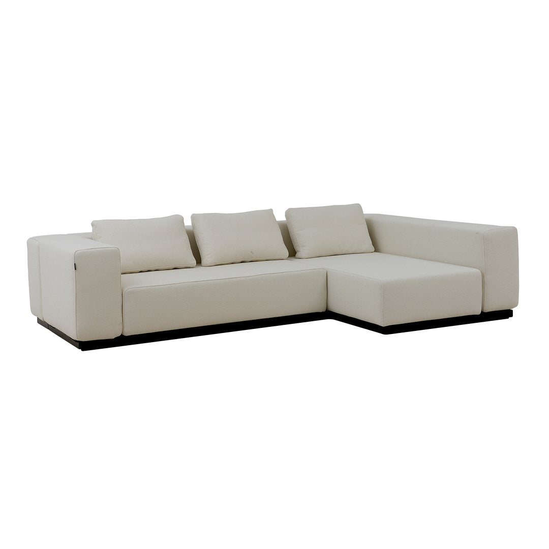 Modern white sectional sofa with a sleek design and subtle textured cushions, complemented by a dark wood base.