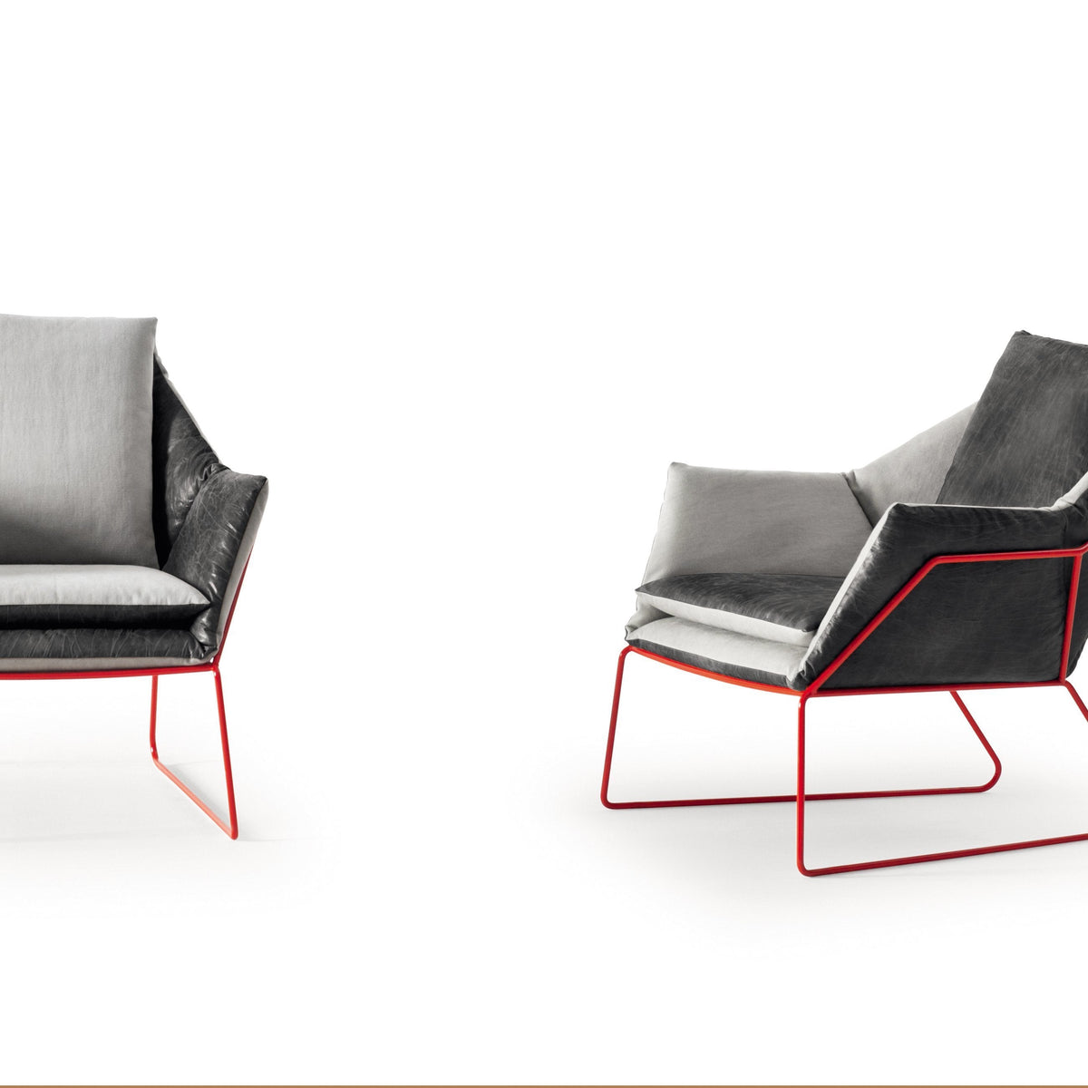 Modern black and gray lounge chairs with vibrant red metal frames, showcasing a sleek geometric design and soft upholstery.