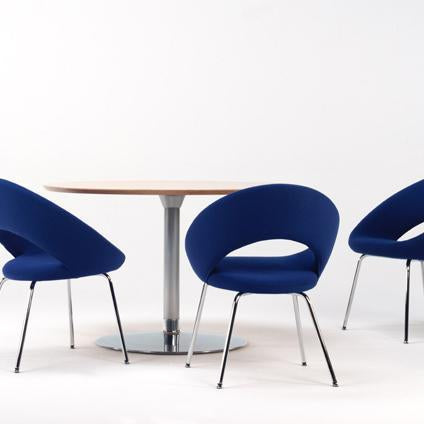 Blue upholstered chairs with sleek, modern design surround a light wood table on a minimalist white background.