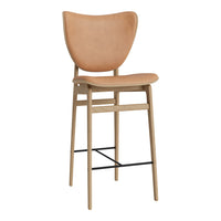 Tan upholstered bar stool with smooth curves and natural wood frame, accented by a sleek black footrest.