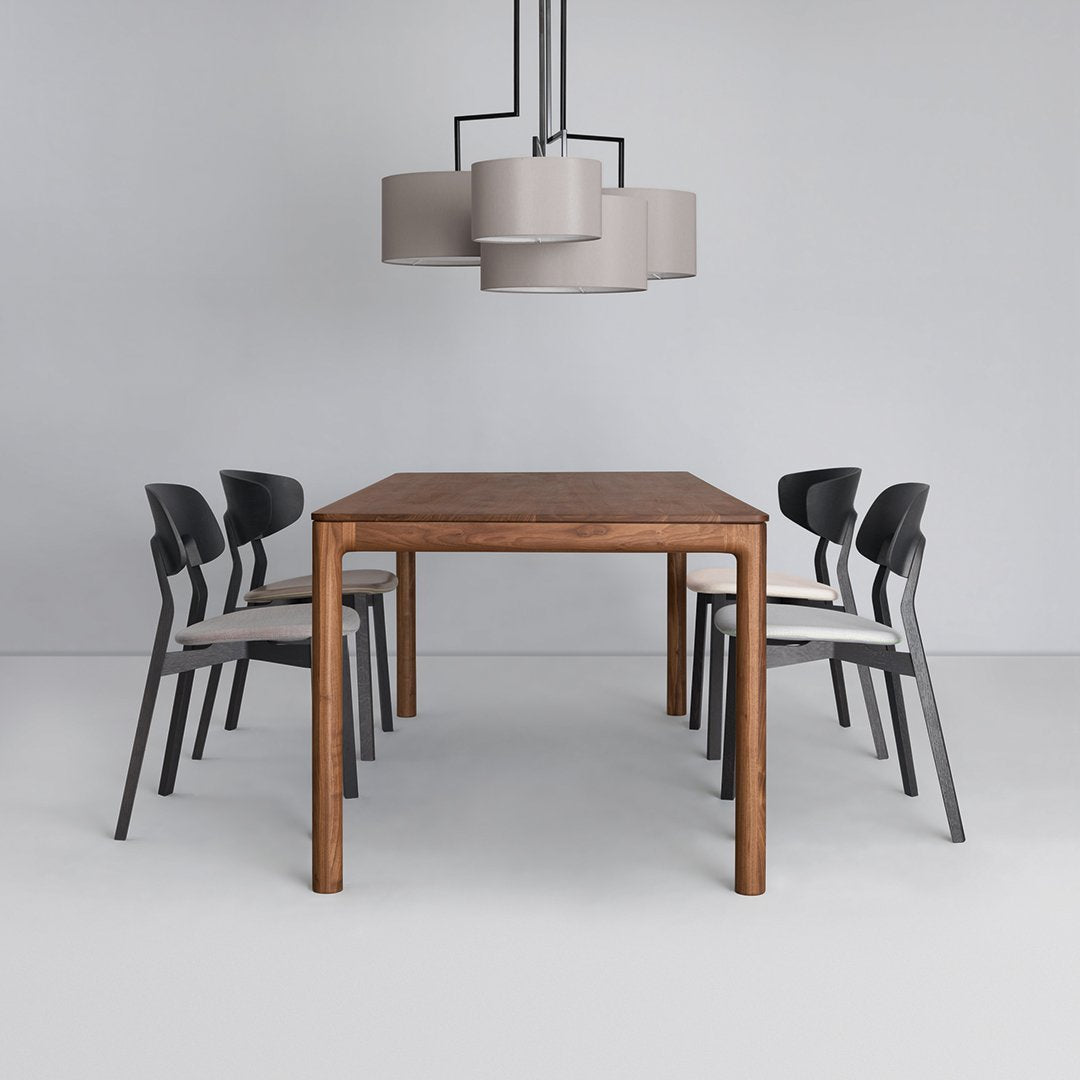 Modern wooden dining table with black and beige chairs, featuring a simple, elegant design and neutral color palette.