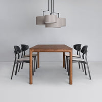 Modern wooden dining table with black and beige chairs, featuring a simple, elegant design and neutral color palette.