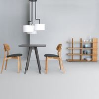 Modern gray dining table with light wood chairs and shelving, complemented by white pendant lights in a minimalist space.