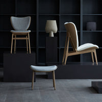 Modern furniture display featuring gray upholstered chairs and soft beige accents against a dark backdrop.