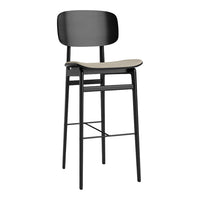 Stylish black bar stool with a smooth light wood seat and minimalist design, perfect for modern interiors.