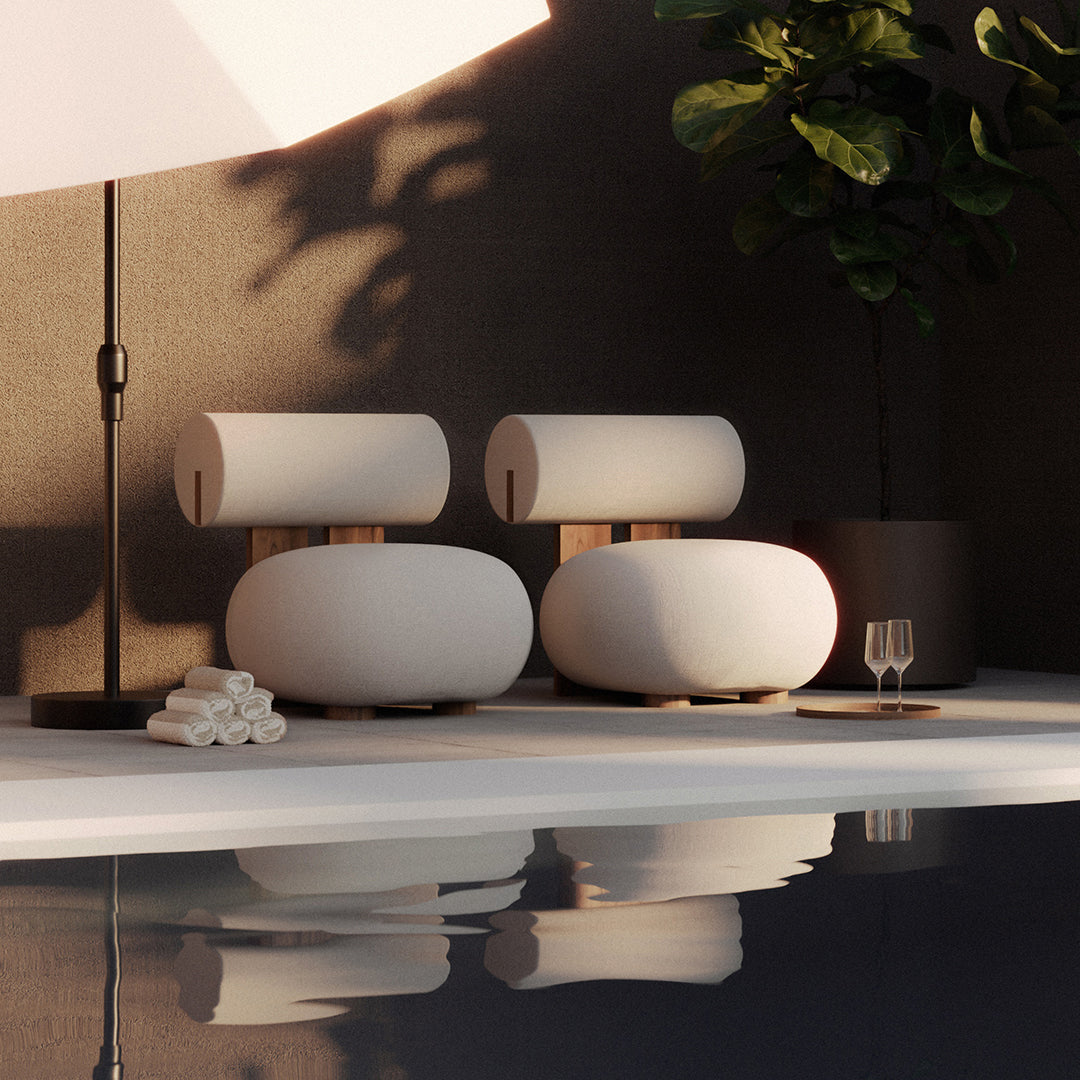 White minimalist lounge chairs with curved shapes, wooden accents, and neutral tones beside a pool.