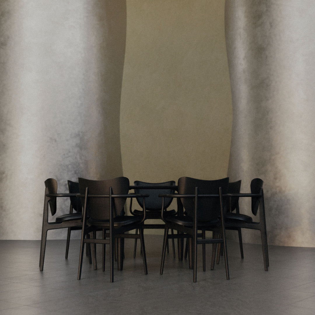Set of six modern black chairs against a textured gold wall and grey floor, showcasing sleek design and minimalist elegance.