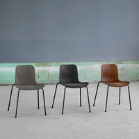 Set of three chairs in muted gray, dark gray, and rich brown with black metal legs against a soft gray background.