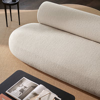 Soft beige, plush textured fabric sofa with a modern, rounded design on a neutral backdrop.