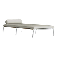 Light gray daybed with a smooth, minimalist design and a cylindrical cushion, featuring sleek metal legs.
