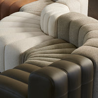 Textured sofa in earthy tones of beige, gray, and brown with a modern, curved pattern. Ideal for contemporary decor.