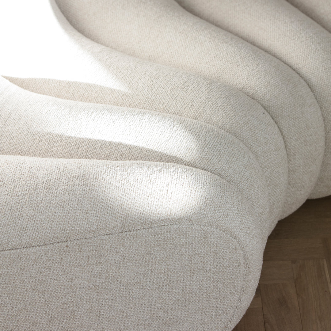Textured cream fabric with soft, wavy contours, featuring subtle light reflections and a modern, elegant design.
