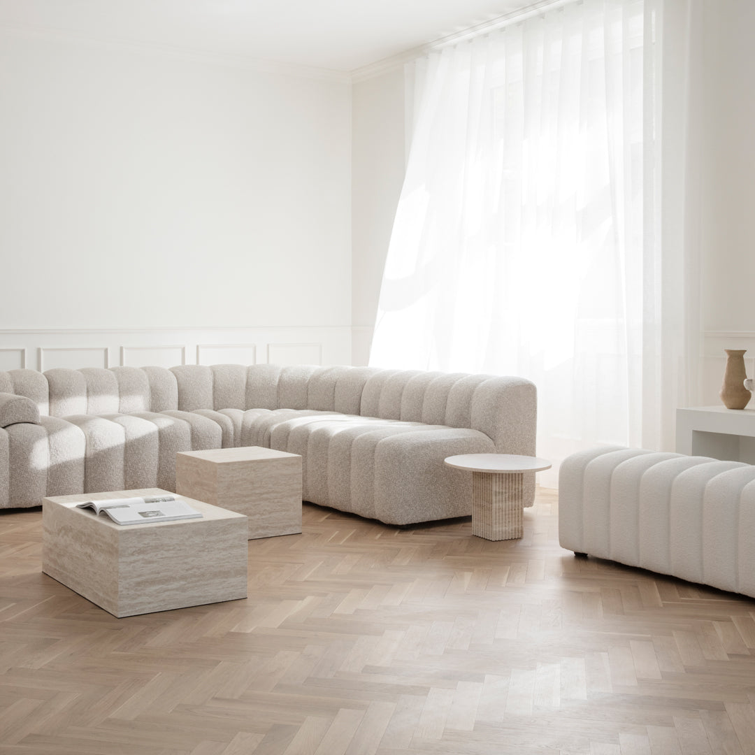 Modern white plush sofa set with textured upholstery and light wood accents in a bright, airy living space.