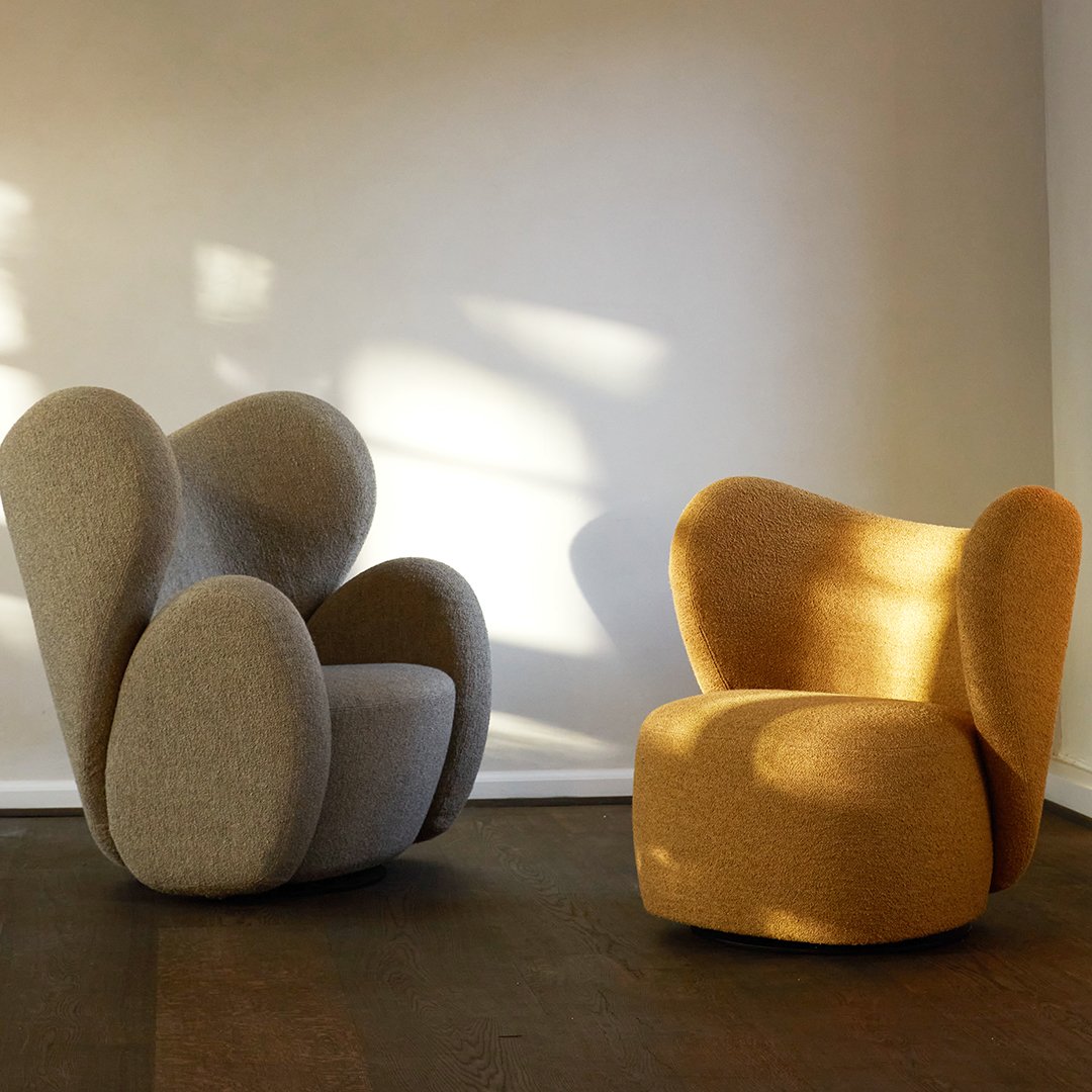Two modern chairs in soft gray and warm mustard yellow, featuring unique curved shapes and textured fabric.