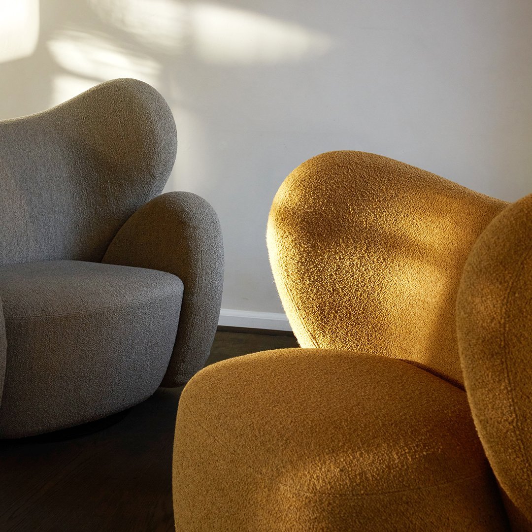 Gray and golden chairs with soft textures and curves, illuminated by warm natural light. Stylish and modern furniture design.