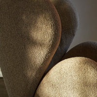 Soft, textured beige upholstery with warm highlights and gentle curves, creating a cozy and inviting aesthetic.