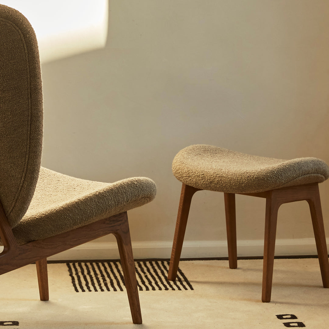 Beige textured upholstery on mid-century chairs, featuring wooden legs and a simple geometric pattern on the floor.