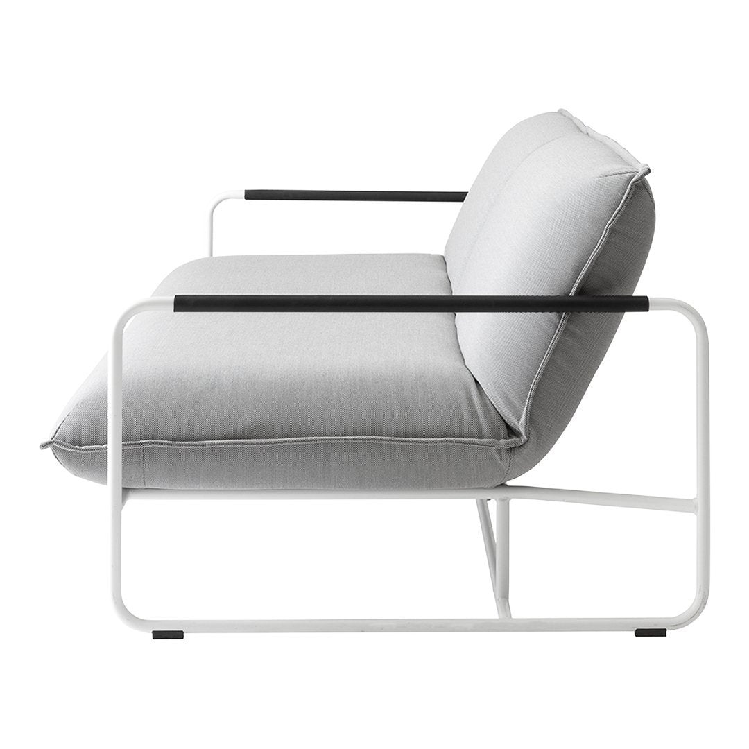 Light gray cushion with black armrests atop a white metal frame, showcasing a modern minimalist design.