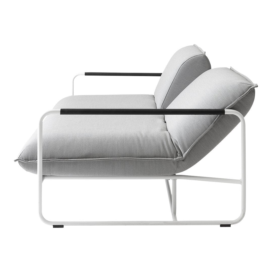 Modern light gray sofa with sleek white frame and black armrests, featuring smooth, minimalist lines and textures.