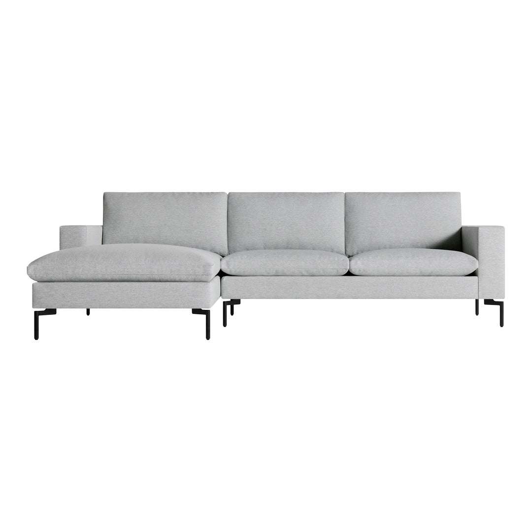 Gray fabric sectional sofa with a minimalist design and black metal legs, featuring smooth, modern lines.