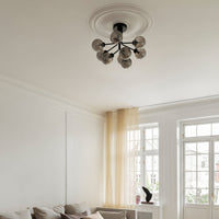 Modern black chandelier with clear glass globes, featuring a sleek round ceiling mount and minimalist style.