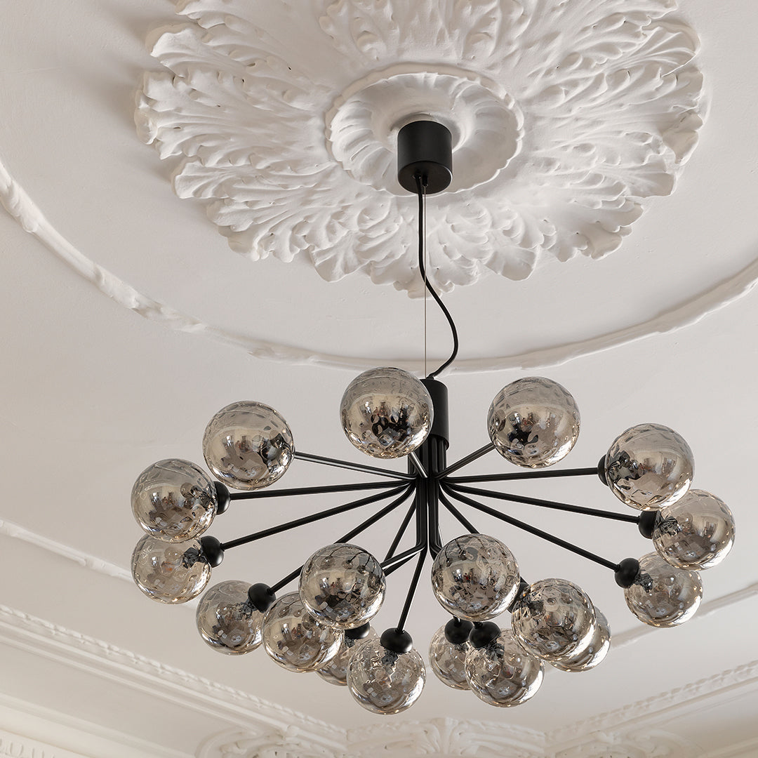 Modern black chandelier with reflective silver globes and ornate white ceiling medallion. Stylish and elegant design.