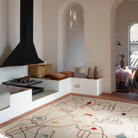 Colorful abstract rug featuring red, blue, and yellow geometric patterns on a cream base, enhancing modern decor.