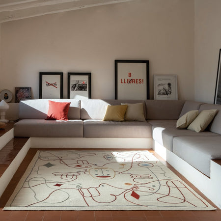 Light cream area rug with abstract red and green patterns, enhancing a modern living room decor.