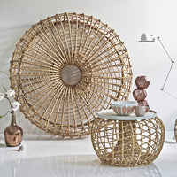 Gold woven pattern decor with cream tabletop, complemented by earthy pottery and a textured round wall art.