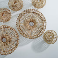 Natural woven rattan baskets in varied sizes and circular patterns, showcasing earthy tones and intricate designs.