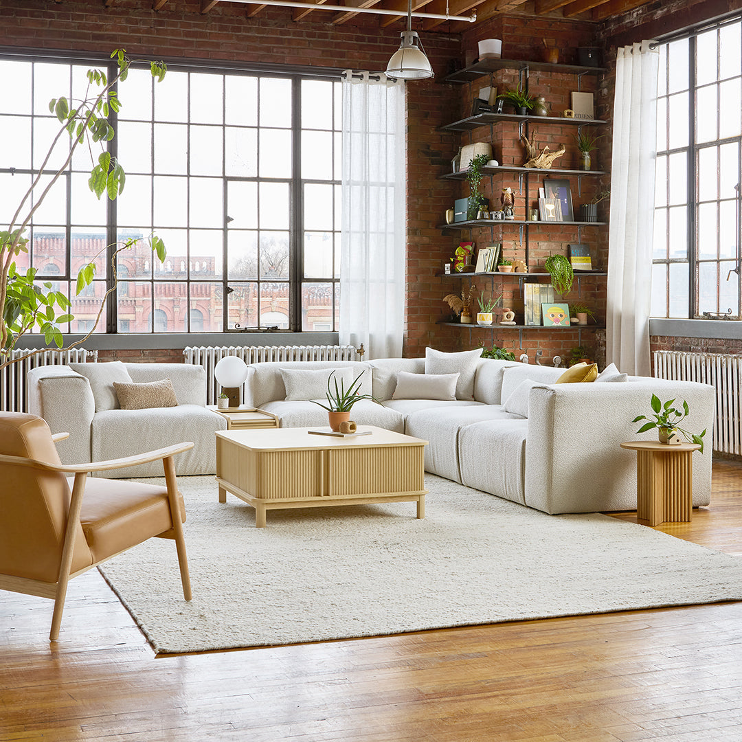 Modern living room featuring soft white tones, beige accents, and natural wood textures in a cozy setting.